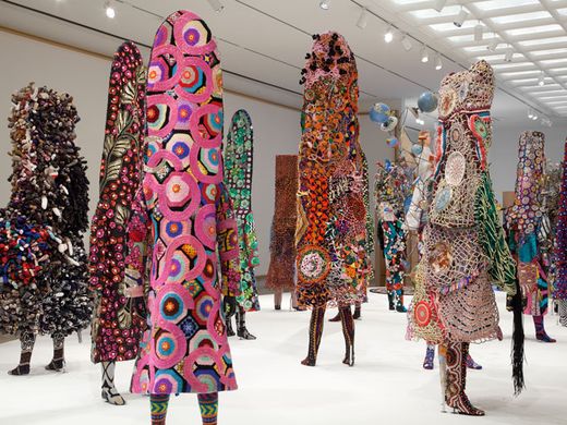Colorful fabric figures stand on white surface