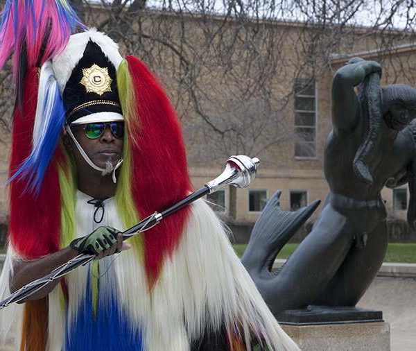 Man in fur helmet holding black and silver scepter