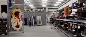 Man moves painting in storage room