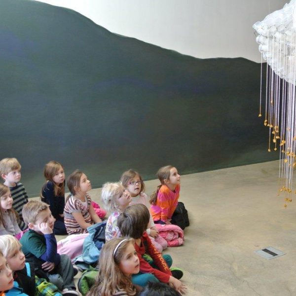 children look up at hanging sculpture