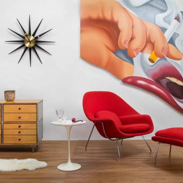 red chair and ottoman next to white table and large wall art