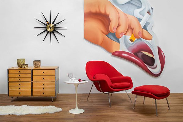 red chair and ottoman next to white table and large wall art