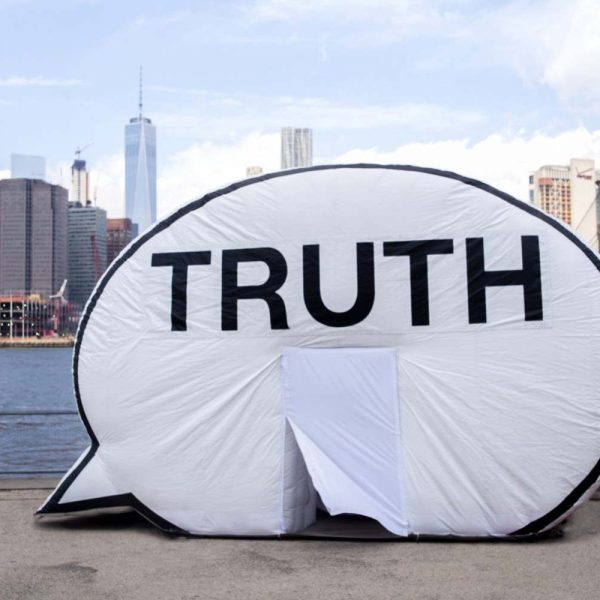 inflated speech bubble in front of water and cityscape