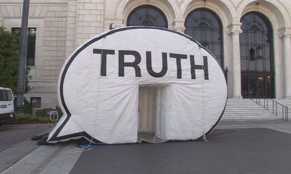 inflatable speech bubble truth booth sits on sidewalk