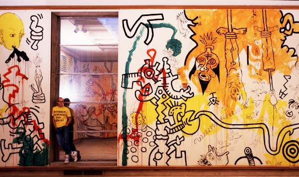 Keith Haring poses with his art