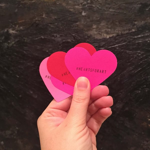 pink and red hearts held in a hand - Hearts for Art campaign