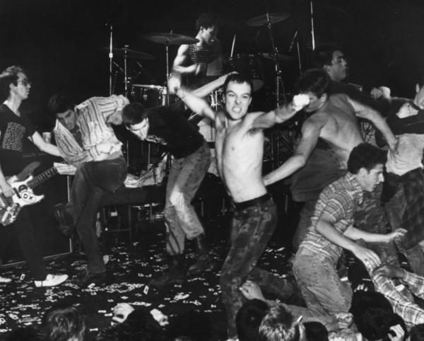 punk band performing on stage and removing clothing