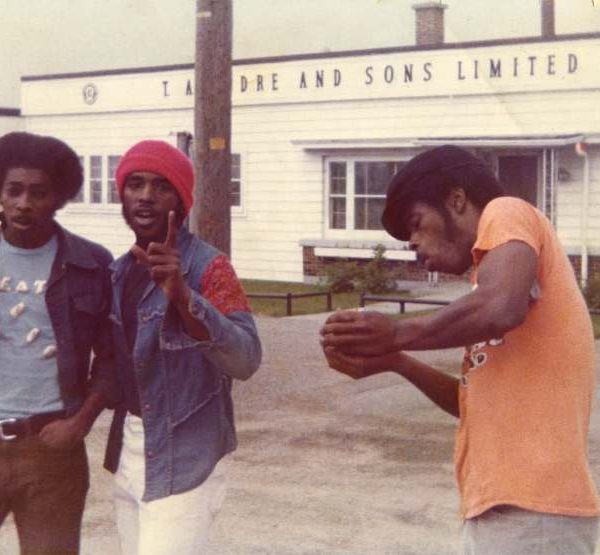 three men talking and standing in parking lot