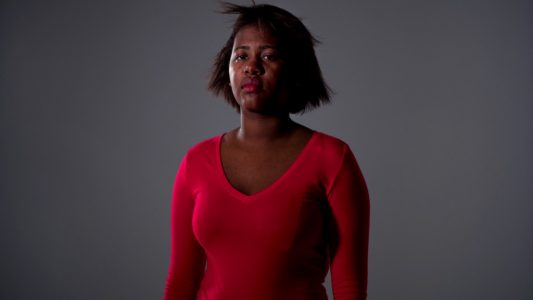 Woman looking at camera wearing red shirt, Danielle Dean