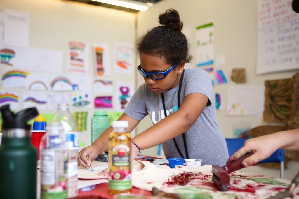 Child with glasses painting